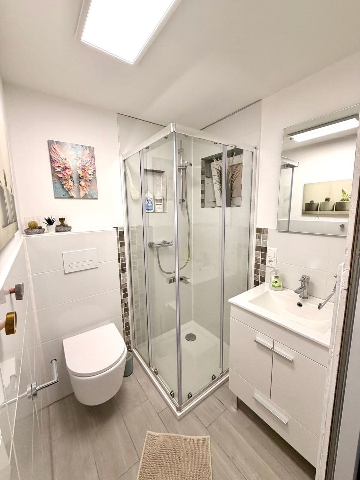 Badezimmer mit Eckdusche, Waschtisch und WC